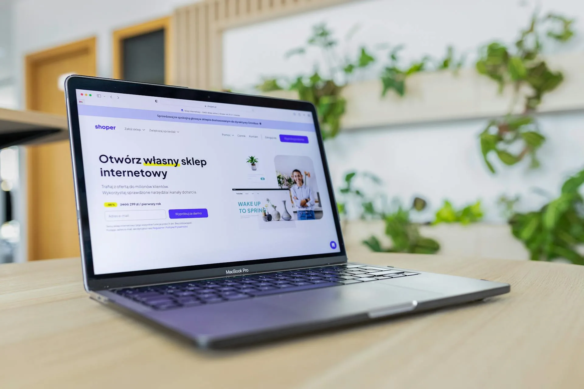 Close-up of a laptop showing a website, surrounded by modern office decor